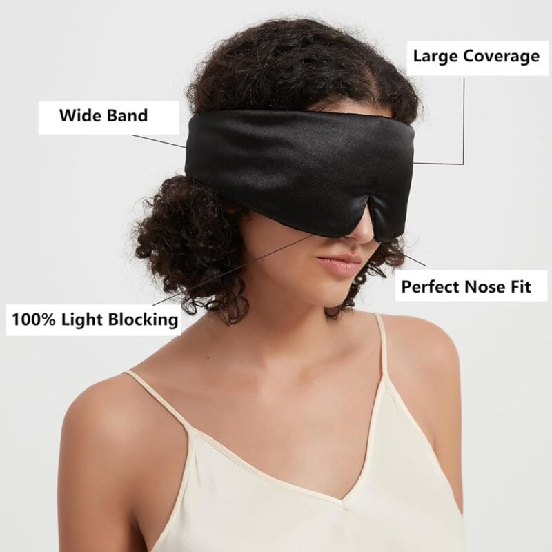 Schwarze Seiden-Schlafmaske mit breitem Band und Fokus auf 100% Lichtblockierung.
