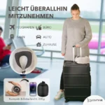Frau mit Koffer am Flughafen, an dem ein graues Reise Nackenkissen Memory Foam befestigt ist. Eingeblendete Symbole zeigen verschiedene Einsatzorte: Flughafen, Büro, Bahn, Auto, Zuhause. Kleines Bild zeigt das zusammengerollte Kissen in einer Tasche.