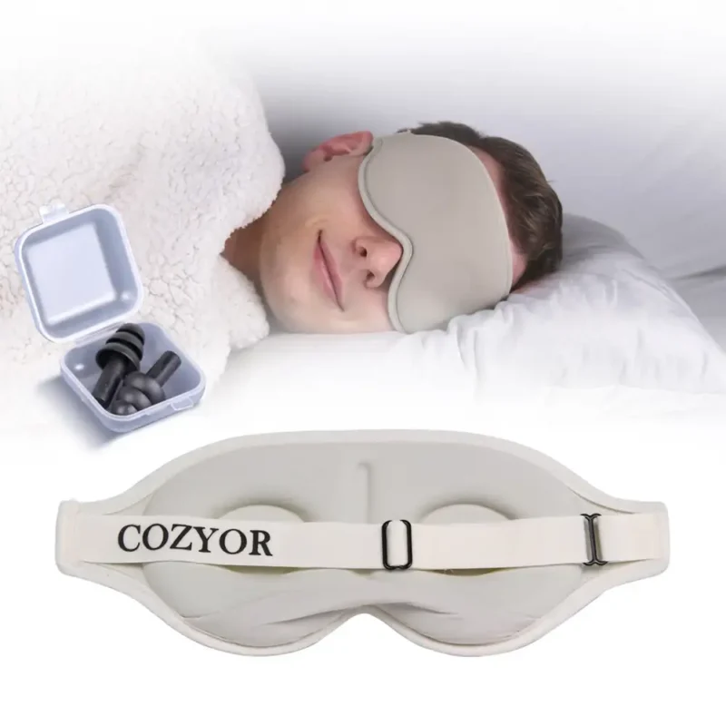 Schlafmaske und Ohrstöpsel für ungestörten Schlaf. Eine Person liegt entspannt im Bett mit einer beigen ergonomischen Schlafmaske, während daneben eine Box mit Ohrstöpseln geöffnet ist. Unten ist die verstellbare Rückseite der Schlafmaske zu sehen.