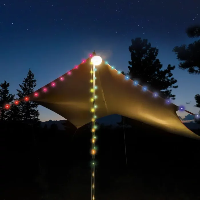 Bunte LED-Lichterkette, gespannt über ein Zelt im Wald bei Nacht, mit Farben wie Rot, Blau, Gelb, Grün und Lila – stimmungsvolle Beleuchtung unter Sternenhimmel.