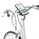 Das Bild zeigt eine Handyhalterung am Lenker eines Fahrrads. Das Smartphone ist horizontal befestigt und wird durch flexible Gummibänder sicher gehalten. Die Fahrrad Handyhalterung sitzt direkt über dem Vorbau.
