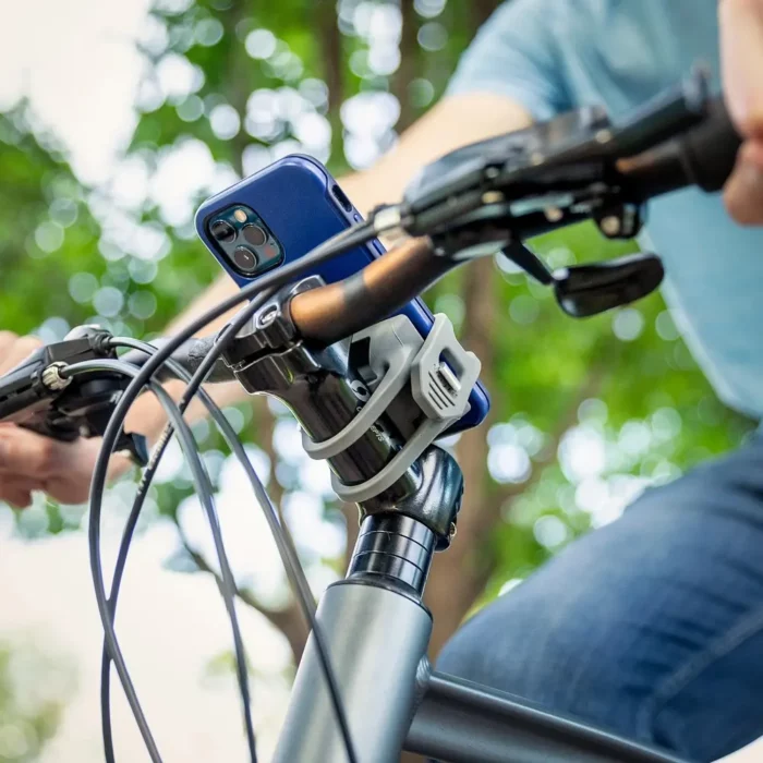 Montierte Handyhalterung am Fahrradlenker, in der ein Smartphone sicher eingespannt ist. Die Befestigung erfolgt mit elastischen Bändern um den Vorbau.
