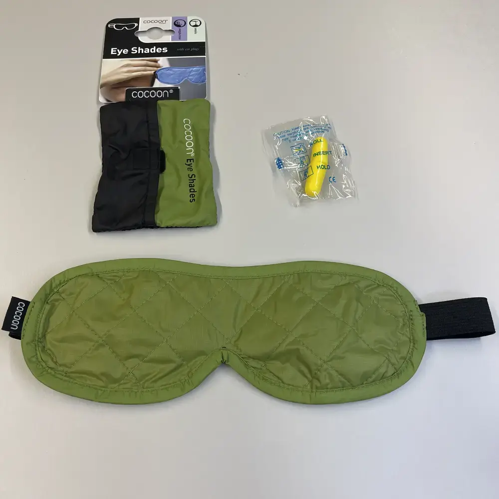 Cocoon-Maske mit Etui, Ohrstöpseln und Verpackung auf Tisch