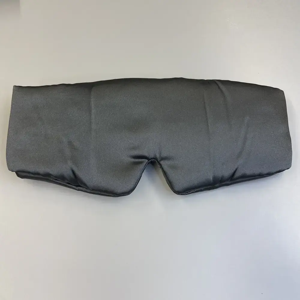 Kitsch Schlafmaske von oben fotografiert, flach auf einem hellen Tisch liegend