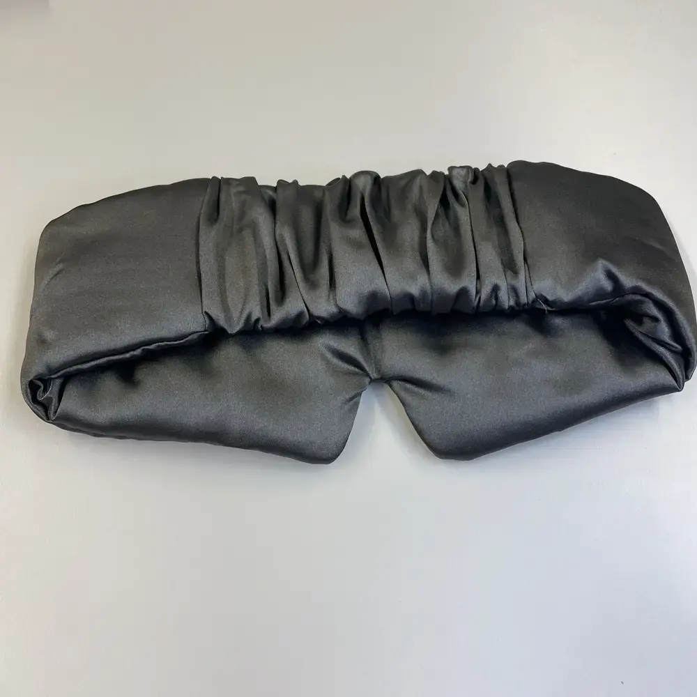 Rückansicht der Schlafmaske mit gerafftem Satinband in dunklem Grau