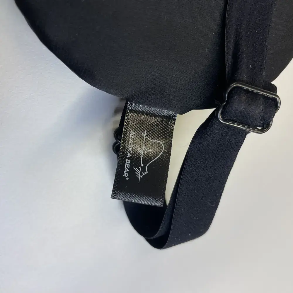 Nahaufnahme des ALASKA BEAR Logos auf dem seitlich angenähten Etikett der Schlafmaske.
