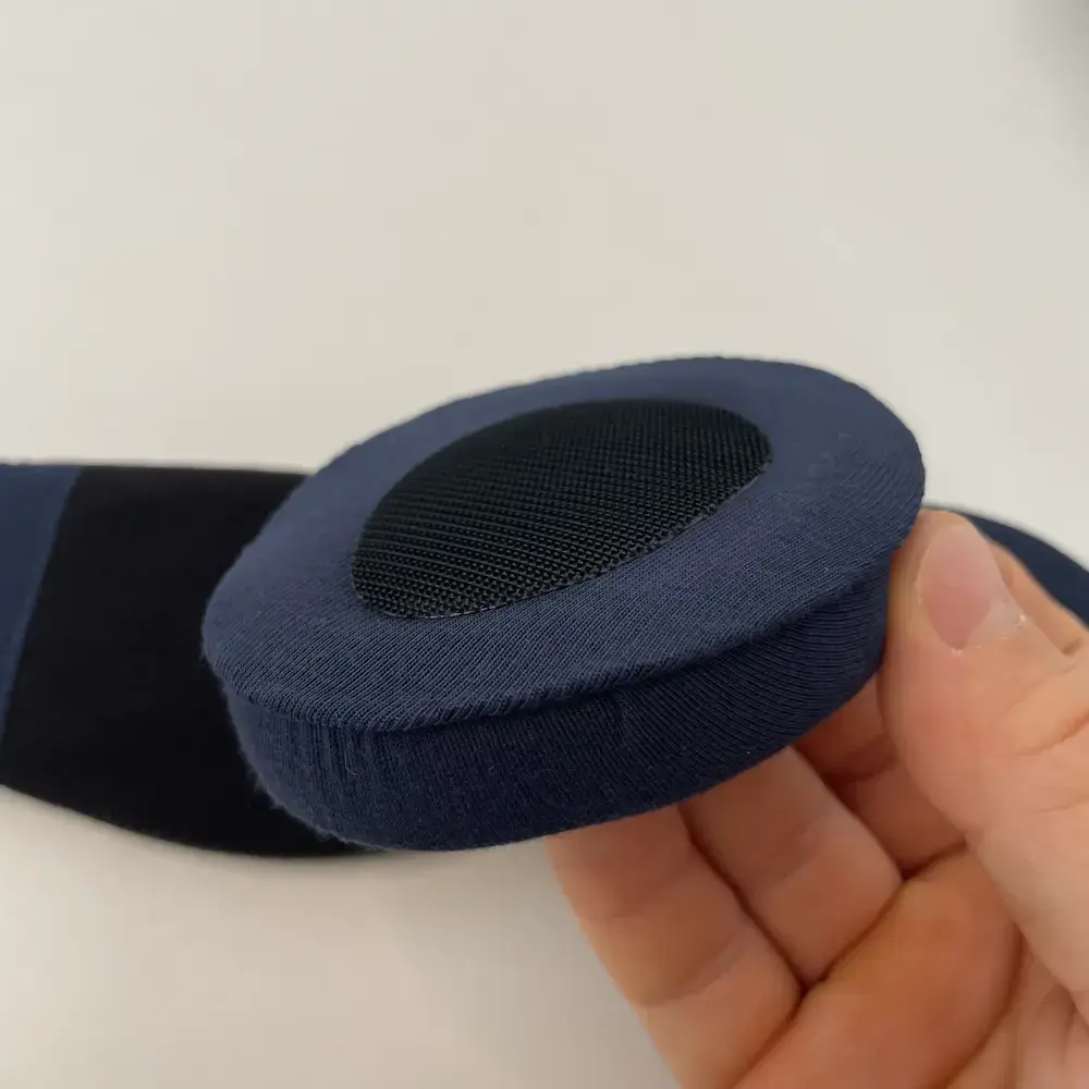 Einzelnes Augenpolster Nahaufnahme: Hand hält ein herausnehmbares, gepolstertes Augenpad der Dagsmejan Blackout Schlafmaske mit atmungsaktiver Membran.