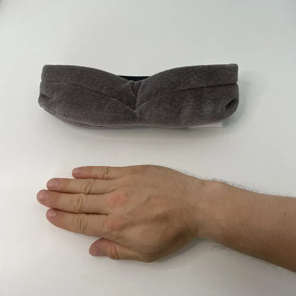 Grössenvergleich der Tempur Schlafmaske mit einer Hand – kompakt und dennoch dick gepolstert.