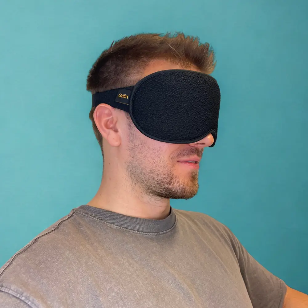 Seitliche Ansicht der getragenen Gritin Schlafmaske an einem Mann vor türkisfarbenem Hintergrund