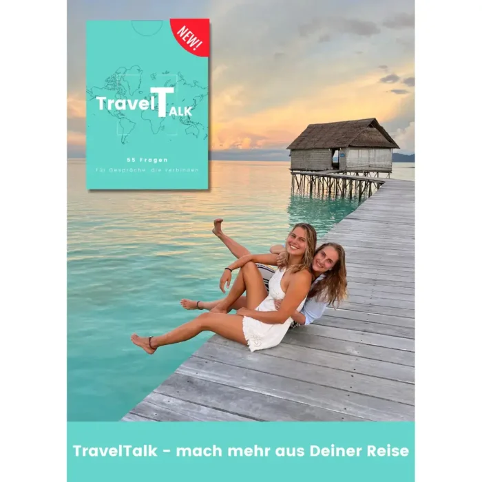 Zwei Frauen sitzen lachend am Rand eines Holzstegs über türkisfarbenem Wasser mit Blick auf eine Strandhütte bei Sonnenuntergang. Oben links ist das Kartenset TravelTalk mit 55 Fragen für Gespräche abgebildet.