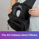 Person verstaut ein schwarzes Cabeau Nackenkissen im Hauptfach eines offenen Sling Packs mit pinken Reissverschlüssen. Unten steht: „Fits All Cabeau Neck Pillows“.