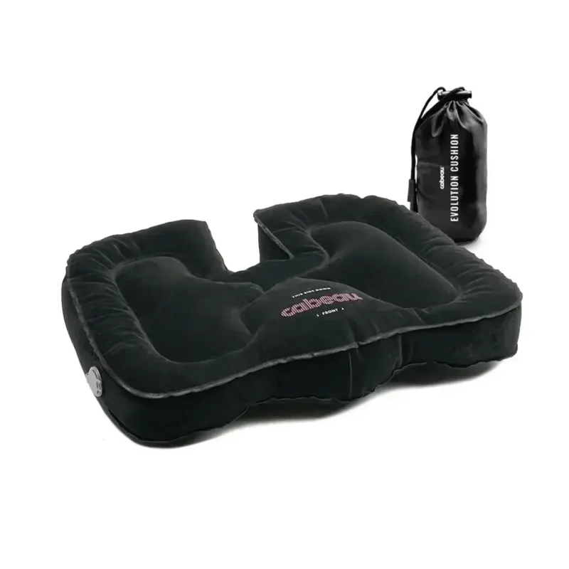 Schwarzes aufblasbares Sitzkissen mit ergonomischer Aussparung und separatem Transportbeutel im Hintergrund, auf weissem Untergrund fotografiert.