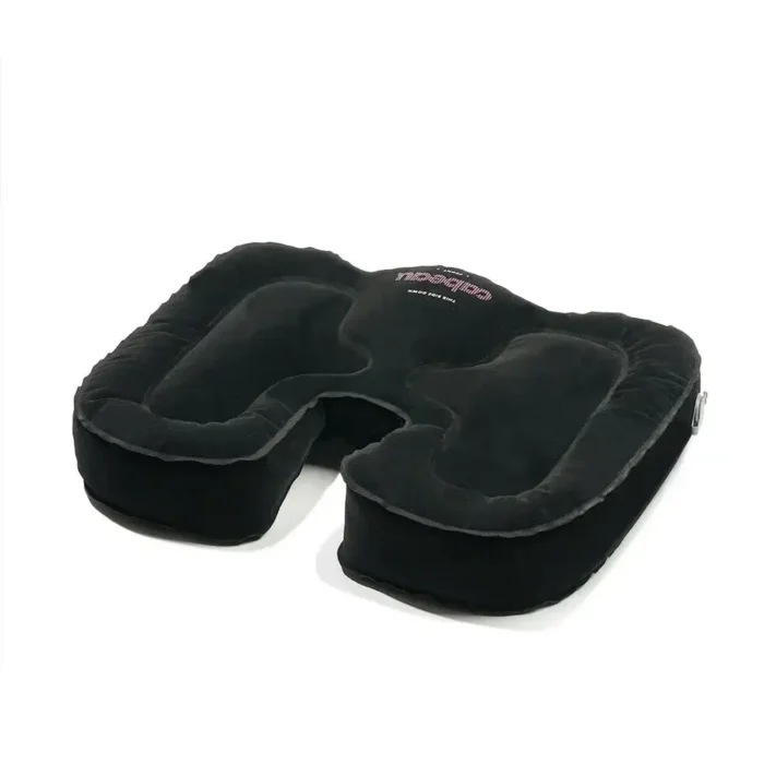 Schwarzes aufblasbares Sitzkissen in Hufeisenform mit ergonomischer Aussparung, aufgeblasen auf weissem Hintergrund liegend.