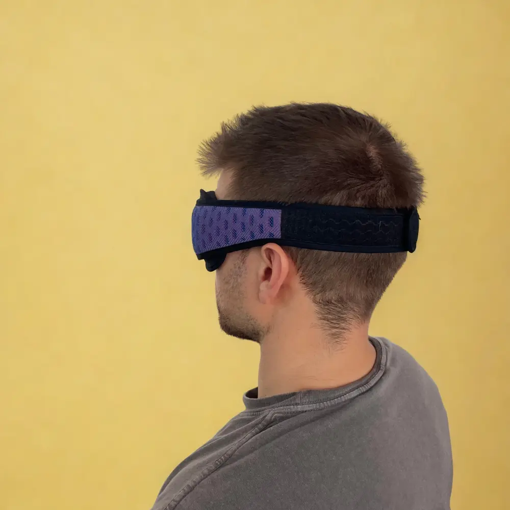 Mann von hinten mit getragener Manta Sleep Mask Pro – zeigt den festen Sitz und das breite Kopfband.
