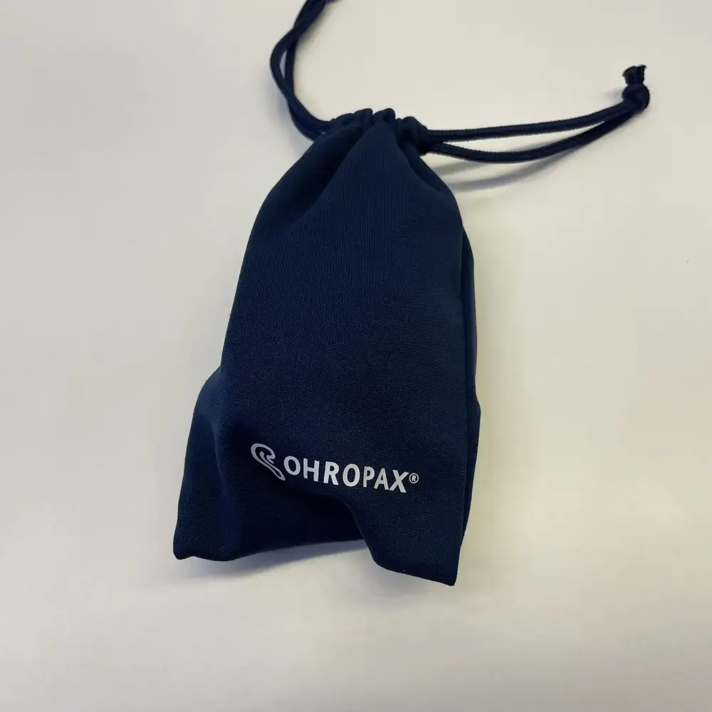 OHROPAX Schlafmaske in dunkelblauem Beutel mit Logo, zusammengezogen mit Kordelzug
